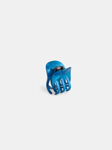 The Small Round Claw, a blue acetate hair clip with curved prongs, stands upright on a white background, highlighting the quality of premium acetate accessories.