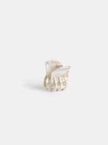 The Small Round Claw is a handcrafted hair accessory made in France from cream and beige marbled acetate, featuring a gold hinge. It is shown on a plain white background.