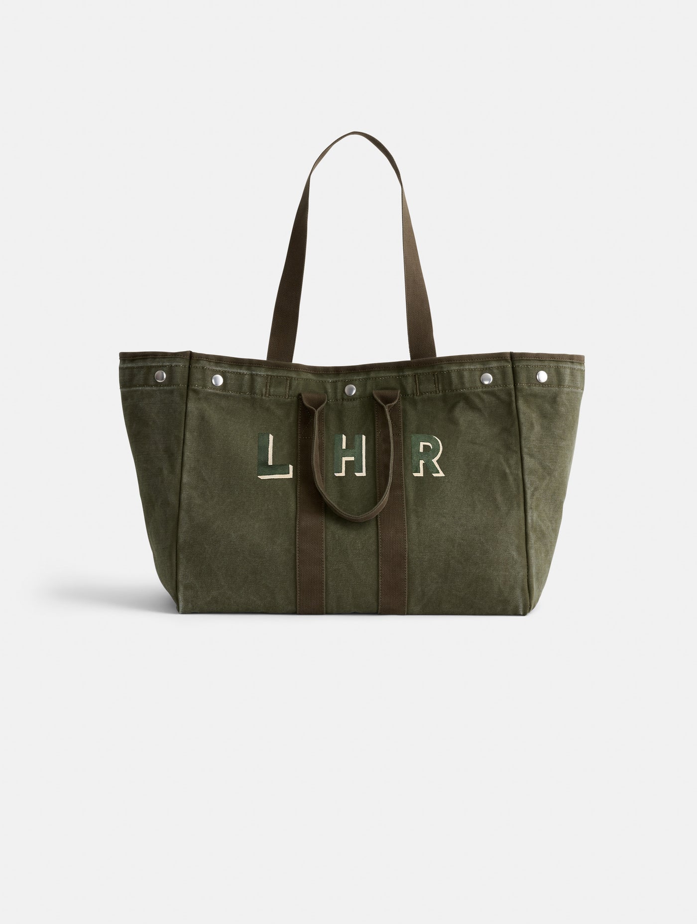 The Painted Perfect Weekend Tote is a large olive green canvas bag with dark brown handles, silver-tone snap buttons, and 