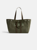 The Perfect Weekend Tote is a large olive green cotton bag with brown handles and trim, featuring "LHR" in white and green on the front. It includes personalized details and metal snaps near the top edges.