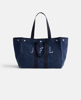 The Perfect Weekend Tote, a spacious navy blue cotton bag with two handles, silver button accents, and 