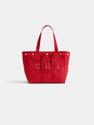 The Painted Perfect Weekday Tote is a red canvas bag with two handles, silver button accents, CHI in white letters on the front, and vertical stitching. The product is displayed against a plain white background.