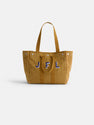 The Perfect Weekday Tote, a tan suede bag with two handles, features large blue and white "JFL" initials on the front and is shown against a plain white background.
