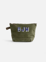 The Perfect Canvas Pouch: Olive green canvas with a brown pull tab, inspired by vintage military style. Bold white and blue "BJW" initials on the front—ideal for use as a unique makeup bag or stylish organizer.