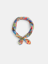 The Alex Mill x Liberty Bandana, featuring a vibrant floral print and crafted from 100% cotton, is styled in a loose knot and arranged in a circle on a plain white background.