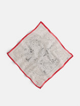The Travel Scarf In Cotton Voile is a square, cream-colored scarf with an intricate black old-world map design and a bright red border, displayed flat on a white background.