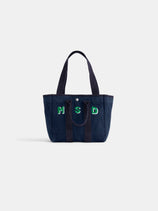 The Perfect Daily Tote is a navy blue cotton bag with two handles, featuring green and white embroidered "M S D" letters on the front—ideal for personalization. Displayed against a plain white background.