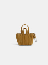 The Teeny Tiny Tote Keychain is a small mustard yellow textured handbag with double handles, vertical stitching, and a keychain on one side, shown against a plain white background.