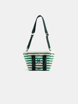 The Painted Striped Mini is a green and white striped tote bag featuring black handles, an adjustable black shoulder strap, and a large M logo on the front, displayed against a plain white background.