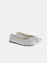 The Porselli x Alex Mill Ballet Flat, a shiny silver slipper with small toe bows and a soft leather sole, made in Italy, displayed on a plain white background.