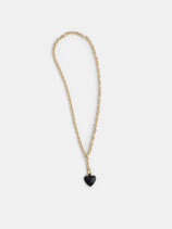 The Roxanne Assoulin Mini Puffy Heart Necklace features a gold puffy heart and a small black heart-shaped pendant on a brass cable chain, shown against a plain white background.