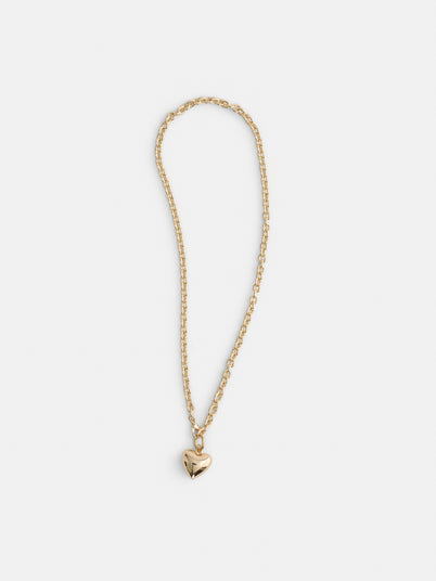 The Roxanne Assoulin Mini Puffy Heart Necklace, featuring a gold brass cable chain and a small shiny puffy heart pendant, is displayed against a plain white background.