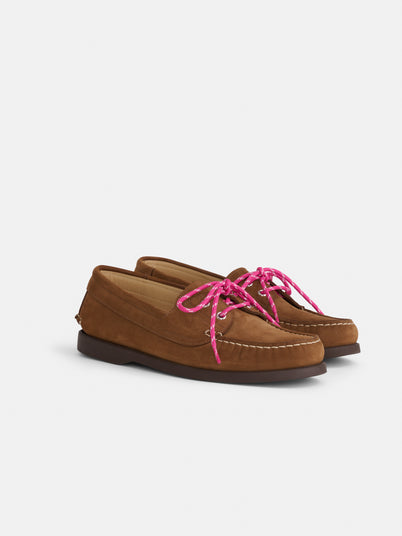 The Tampa Boat Shoe Sister is a brown suede moccasin-style loafer inspired by Italian boat shoes, featuring visible stitching and bright pink shoelaces, displayed against a plain white background.