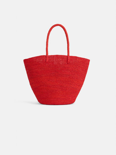 The Mary Mill Tote is a vibrant red handwoven raffia bag with two rounded handles, shown against a plain white background—an ideal summer accessory.