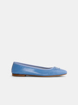 The Prince Street Ballet Flat is a handmade Italian shoe in light blue, featuring a grosgrain bow at the toe, low wooden heel, and glossy finish, shown against a white background.