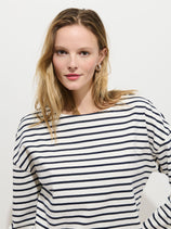 A woman with light brown hair wears the Avignon Striped Tee in Cotton and pearl earrings, standing against a plain white background and looking at the camera with a slight smile.