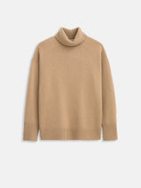 The Maisie Turtleneck Sweater in Cashmere is a beige, long-sleeve sweater with ribbed cuffs, hem, and neckline, shown laid flat on a white background.